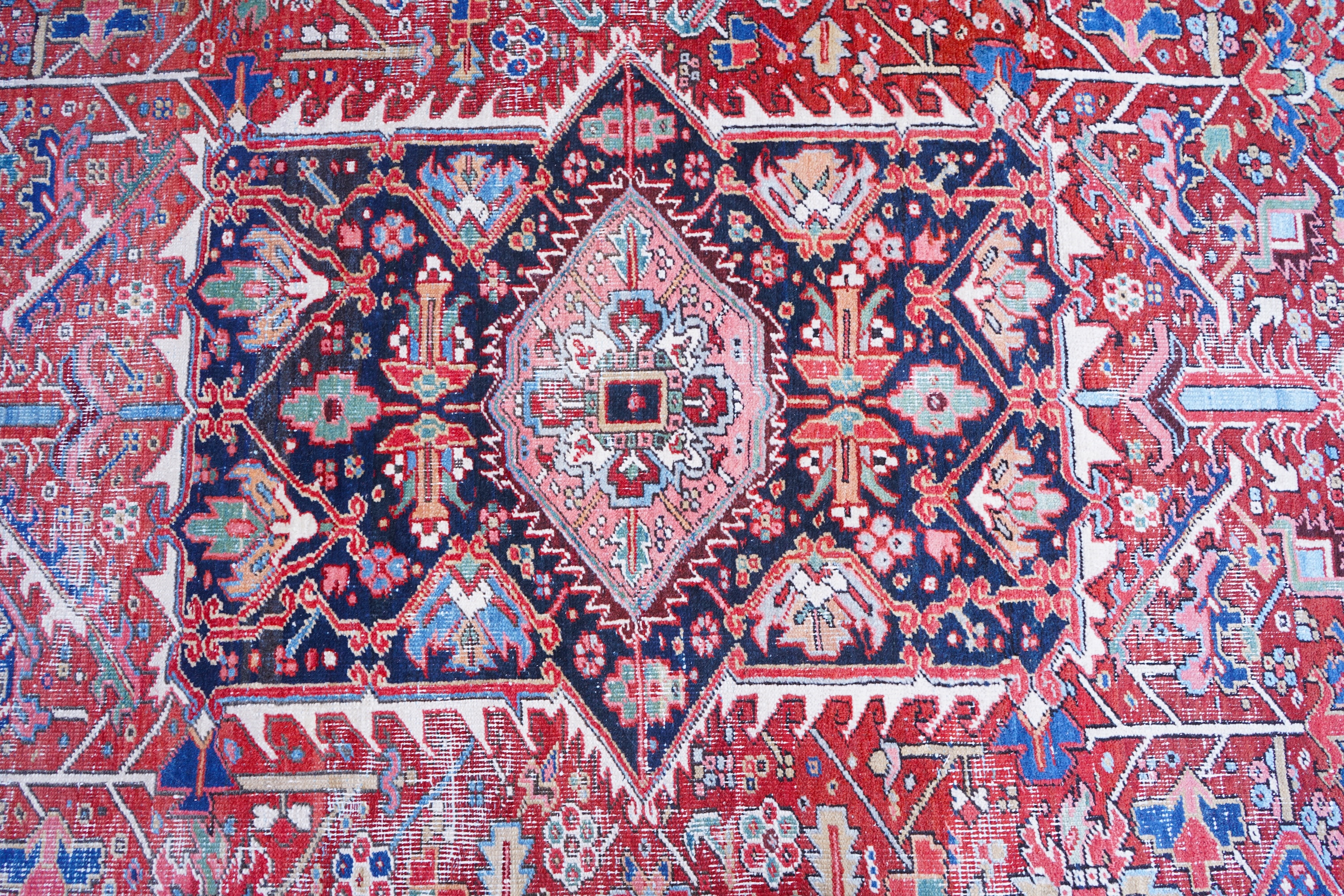 An antique Heriz brick red ground carpet with central